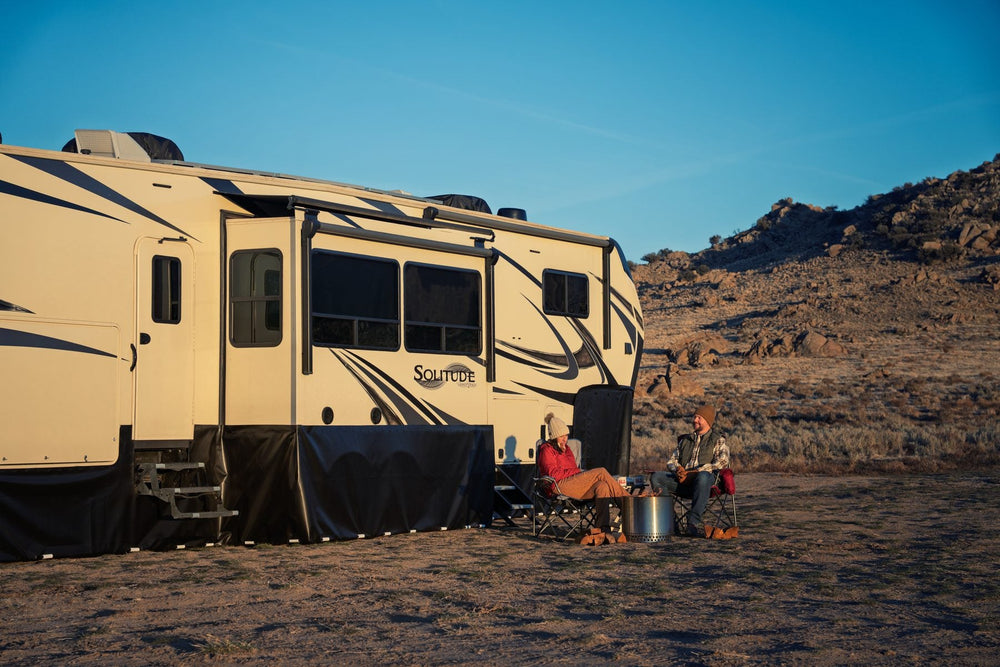 EZ Snap skirting panels enclosing the underbelly of a fifth wheel at golden hour, with owners seated outside