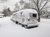 Airstream RV skirted in winter snow