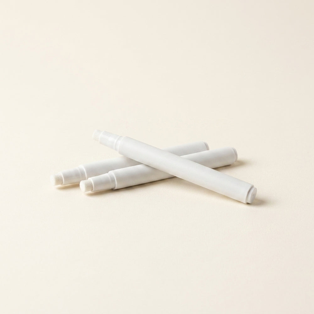 Three white primer pens for prepping the surface before placing studs