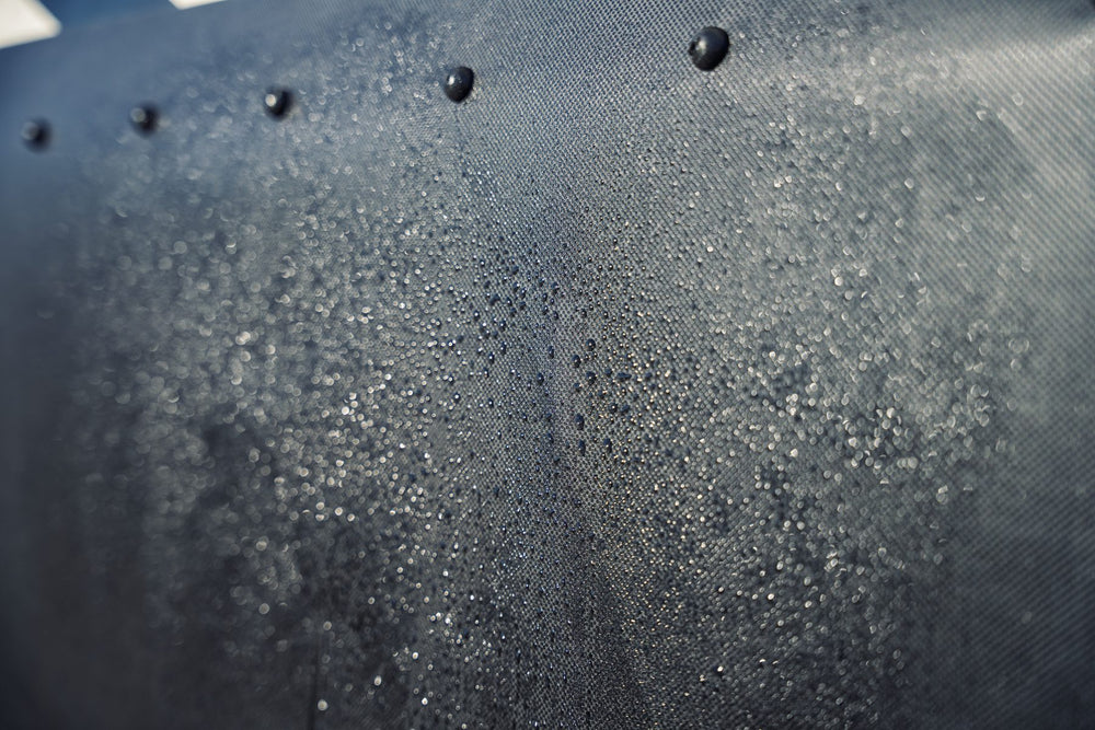 Close-up of black Diamond Weave skirting beaded with water below a row of snaps