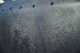 Close-up of black Diamond Weave skirting beaded with water below a row of snaps